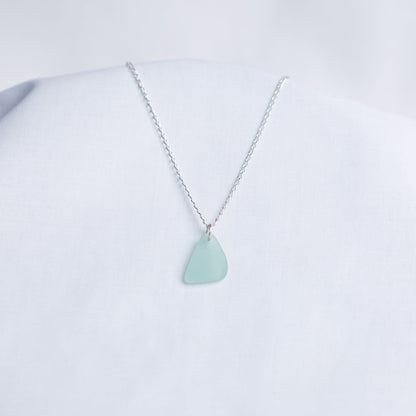 Necklace with a light blue sea glass pendant on a white background