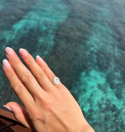 Diver Mon wears silver abalone pinky ring over crystal clear waters of Indonesia