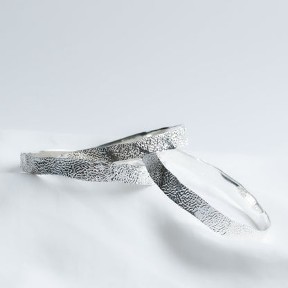 Solid silver bracelet with cuttlefish textured surface on a white background